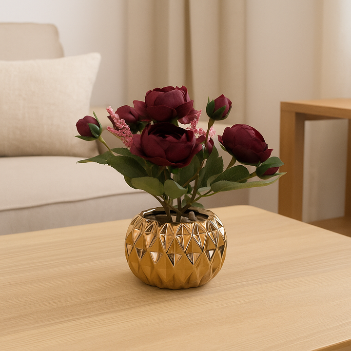 Burgundy artificial roses in a gold porcelain pot