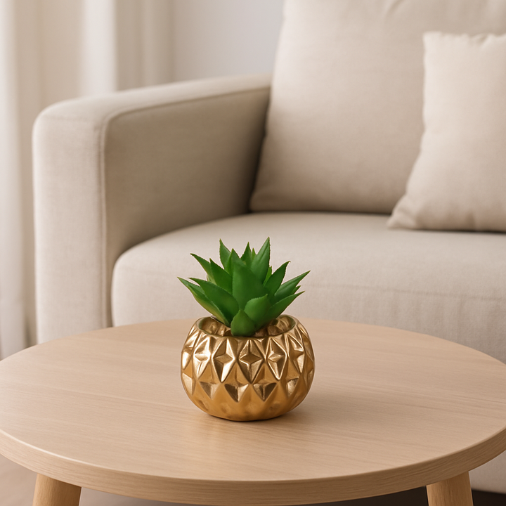 Small artificial cactus in a golden porcelain pot