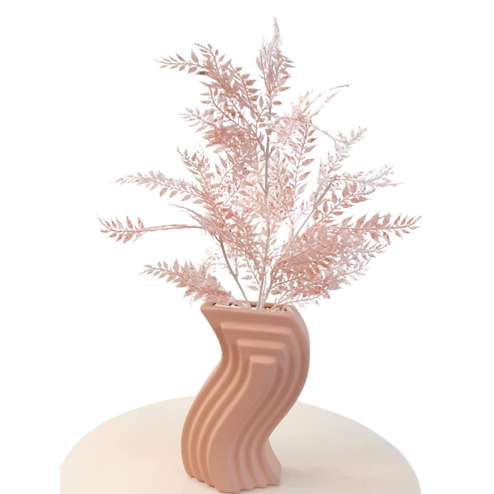 Pink artificial branches in a pink ceramic vase